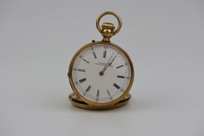 une petite montre de poche en or avec des chiffres romains