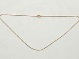 un collier en or avec une chaîne sur fond blanc