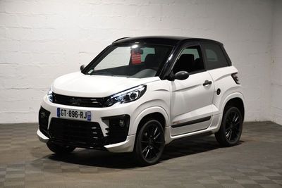 la petite voiture blanche est garée dans une grande pièce