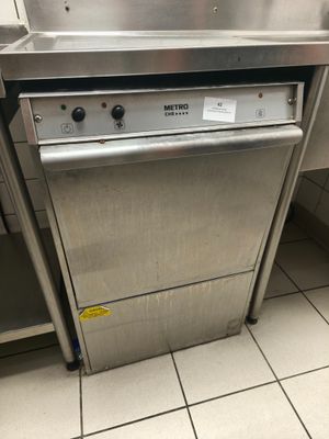 lave-vaisselle en acier inoxydable dans une cuisine professionnelle dotée d'un carrelage au sol