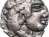 a silver coin with a face of a man and a woman