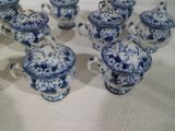plusieurs théières et soucoupes en porcelaine bleue et blanche posées sur une table