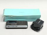 une télécommande et une calculatrice posées à côté d'une boîte