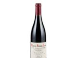 a bottle of red wine sitting on top of a white table
