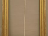 a gold frame with a white string hanging from it ' s side