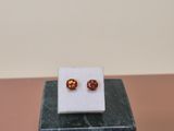 an image of a pair of earrings sitting on top of a marble block