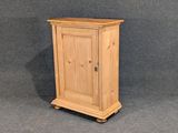 un petit meuble en bois surmonté d'une porte