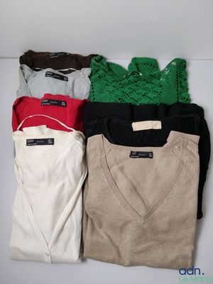 four pairs of sweaters sitting on top of a white table