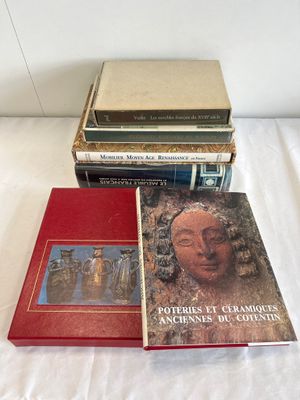 several books are stacked on top of each other on a bed