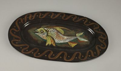une assiette sur laquelle est peint un poisson, posée sur une table