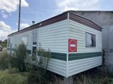 a white and green trailer with a red sign on it