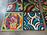 four different colored paintings on the floor of a room