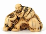 an image of a carved ivory figurine of a man and a dog