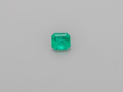 an emerald stone on a white surface