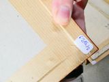 a person holding a piece of wood with a sticker on it
