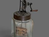 a glass jar with a wooden handle and a metal lid