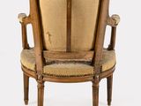 an old wooden chair with a beige upholstered seat