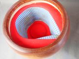 a red bowl with a blue and white checkered cloth inside of it