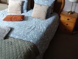 a bed with a blue comforter and pillows on top of it