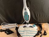 Quelqu'un utilise un balai vapeur pour nettoyer le plateau d'une table.