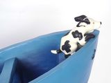 a toy dog that is sitting in a blue boat