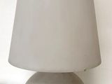 grey ceramic table lamp with a white shade on a white table