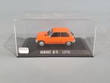 an orange toy car in a clear display case on a white surface