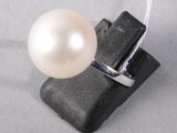 a ring with a pearl on it on a piece of black material