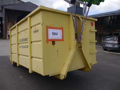 a yellow dumpster that is sitting in the parking lot