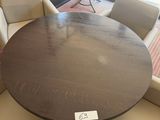a round table with chairs around it in a room