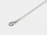 a close up of a necklace on a white surface with a silver chain