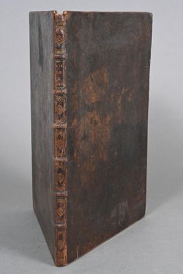 an old book sitting on top of a table next to a white wall