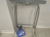 un sac bleu posé par terre à côté d'une étagère en métal