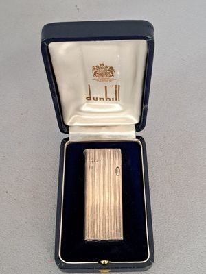 un briquet en argent dans un étui noir posé sur une table