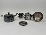 three silverplated teapots and a saucer and a silver plate