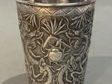 a silver cup with a dragon design on it