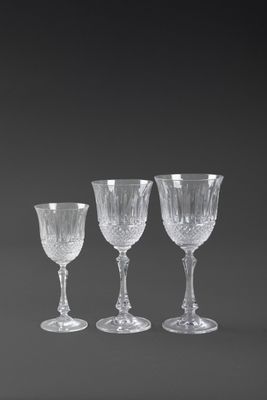 four wine glasses are lined up in a row on a black background