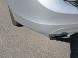 a close up of a car ' s bumper with a cat on it