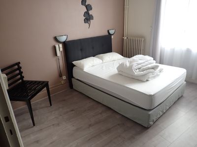 a bed with white sheets on it in a bedroom