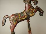 statue d'un cheval posée sur un socle, sur fond blanc