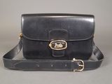a black leather bag with a gold buckle on the front