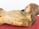 a statue of a man laying down on a red surface