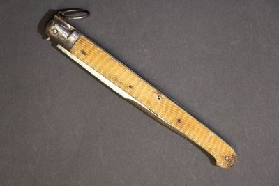 un couteau avec un manche en bois sur une surface noire