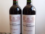 two bottles of red wine sitting on a table