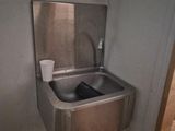 un évier en acier inoxydable dans le coin d'une salle de bains