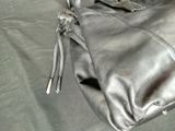 a black purse that is laying on a bed