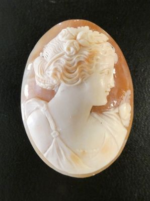 un gros plan du visage d'une femme dans un coquillage sculpté
