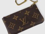 un gros plan d'un porte-clés Louis Vuitton marron sur fond blanc