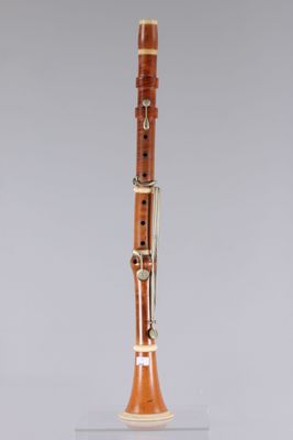 a clarinet with a wooden case on a clear surface
