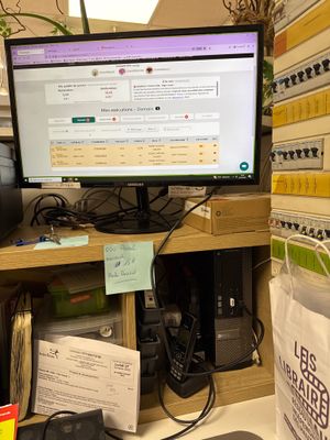 a computer monitor sitting on a desk in a cubicle